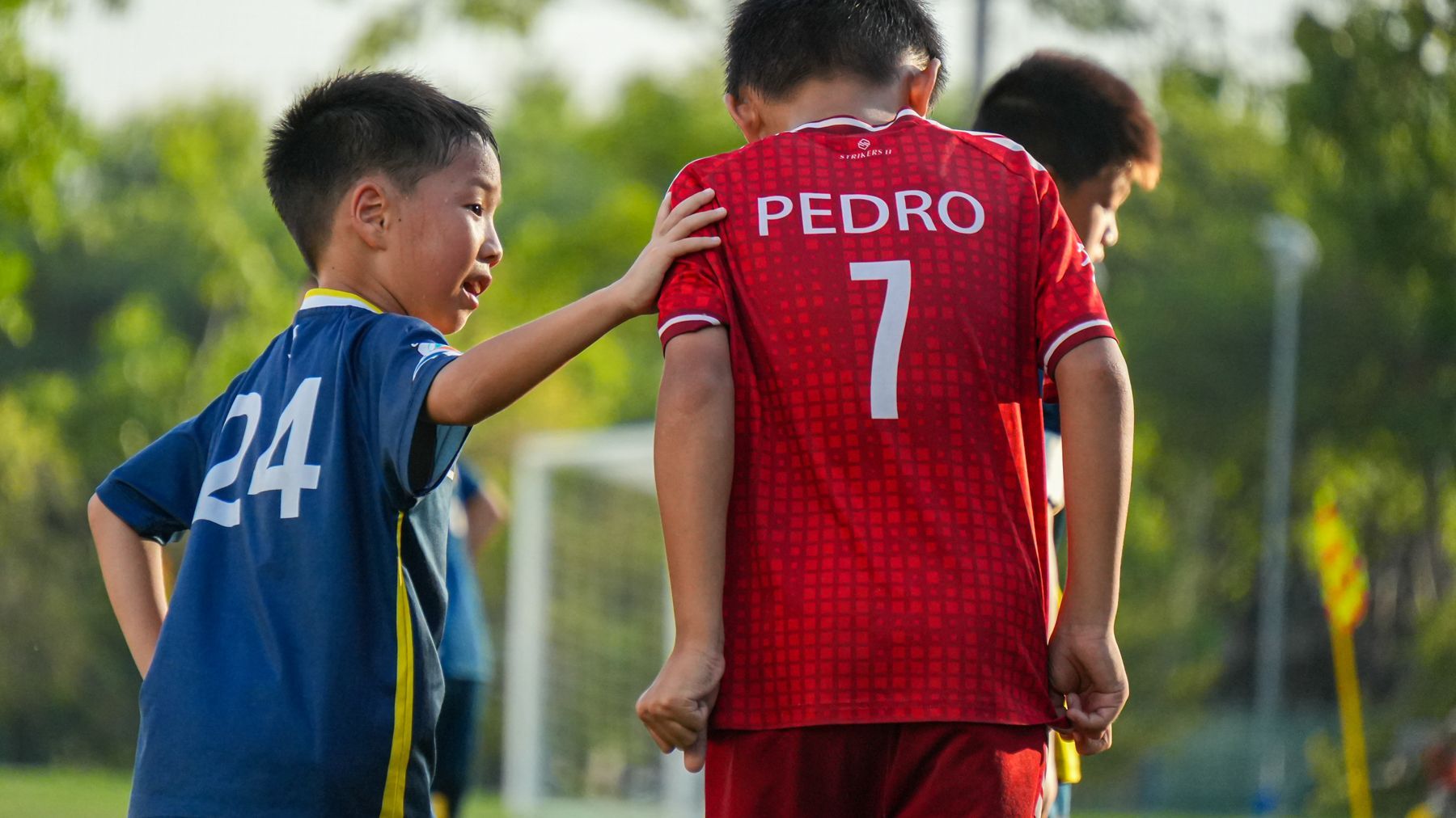 一群小男孩正在操場上踢足球。