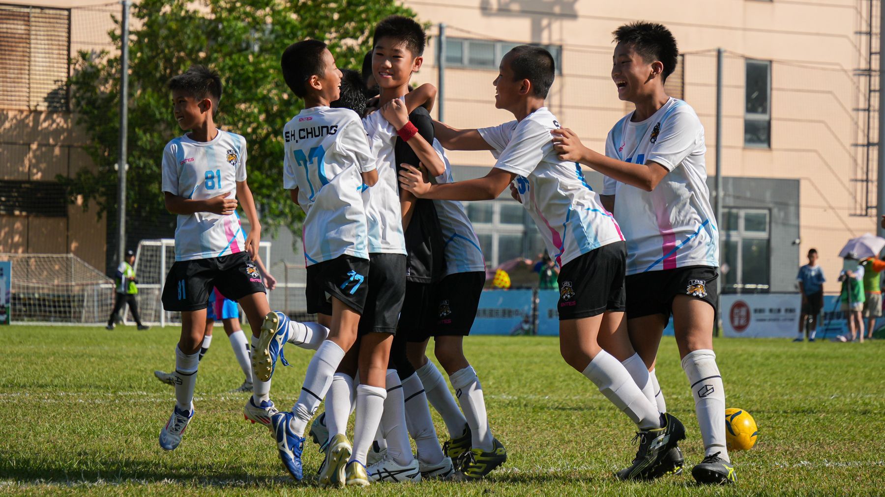 一群小男孩正在操場上踢足球。