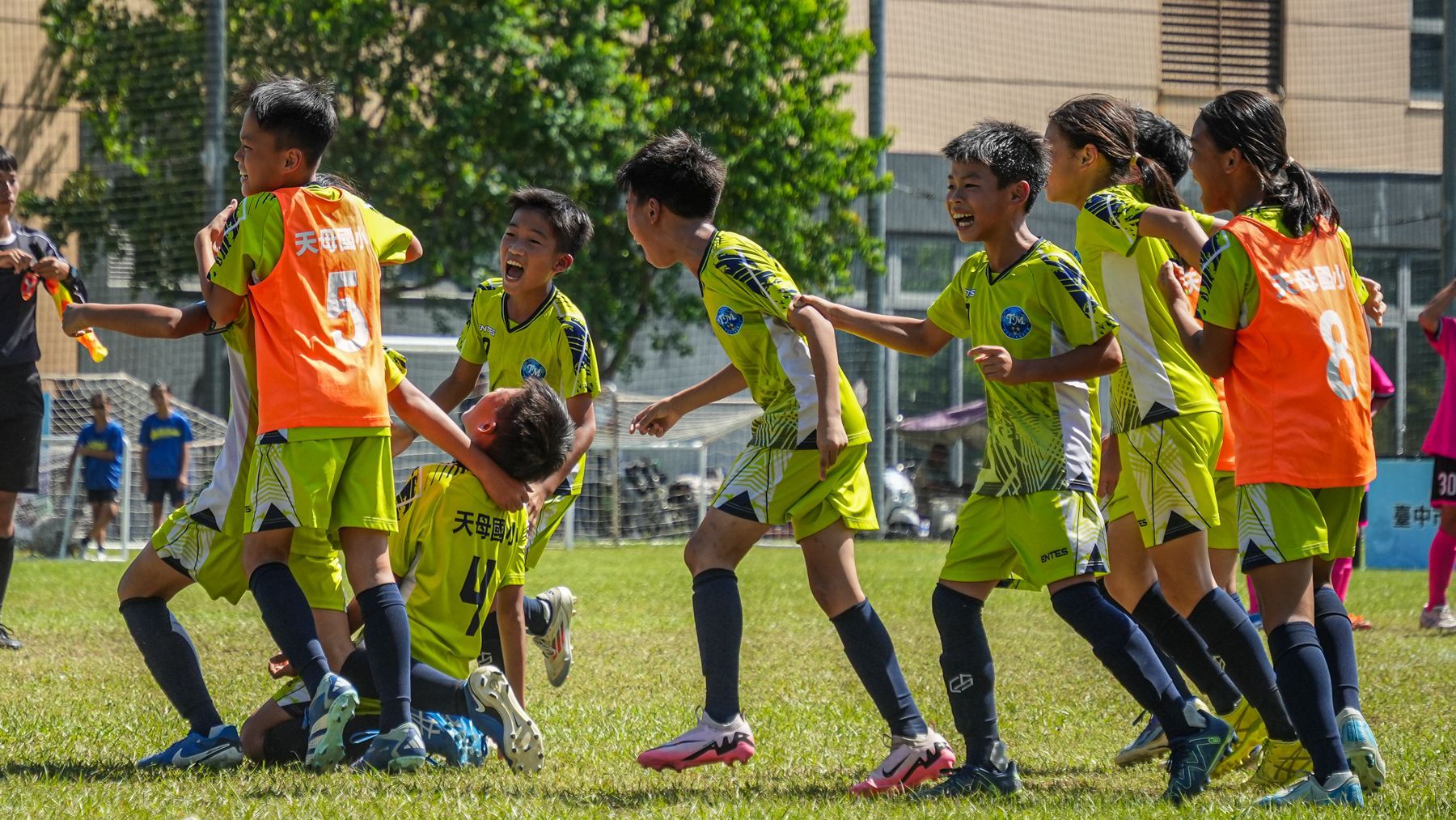 一群小男孩正在操場上踢足球。