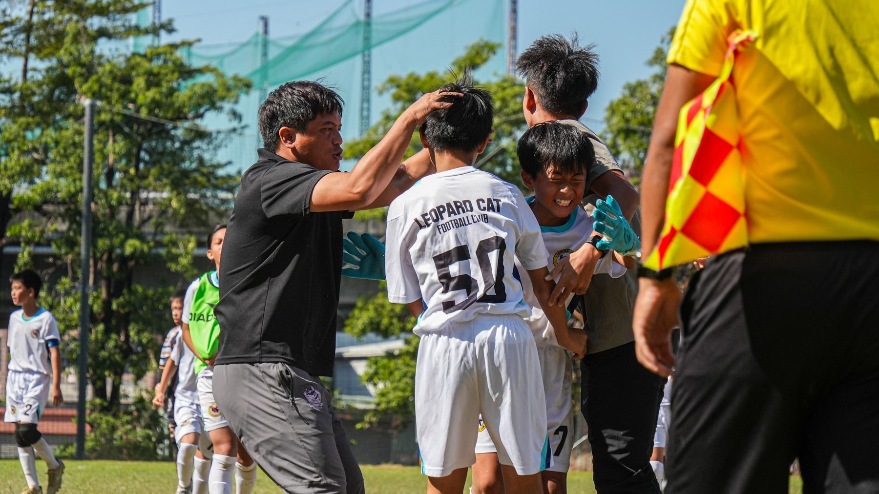 一群年輕人正在操場上踢足球。