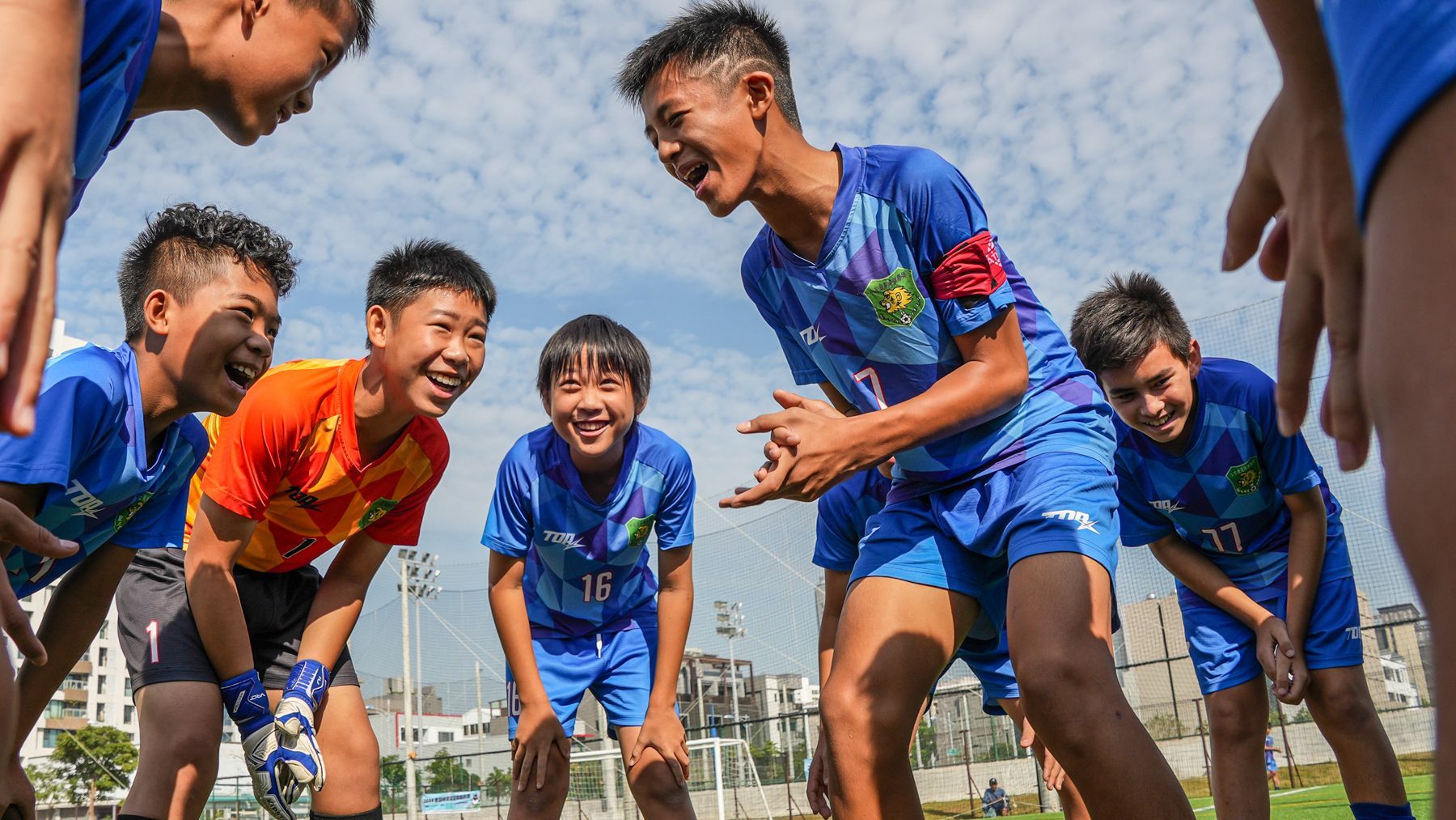 一個男人坐在草地上用相機拍照。
