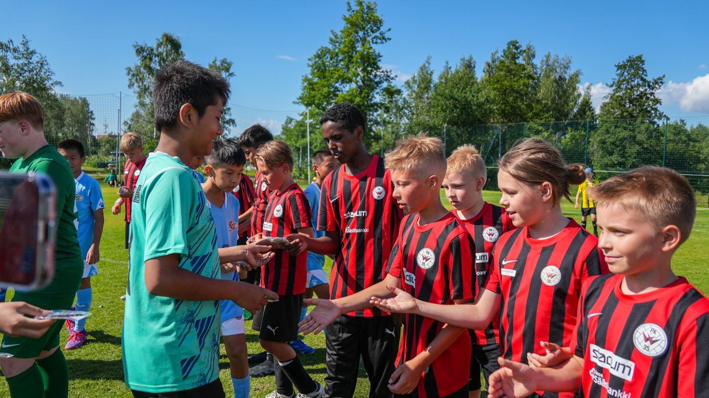 一群小男孩正在足球場上握手。