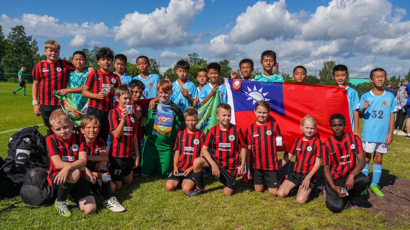 一群小男孩正在足球場上擺姿勢拍照。