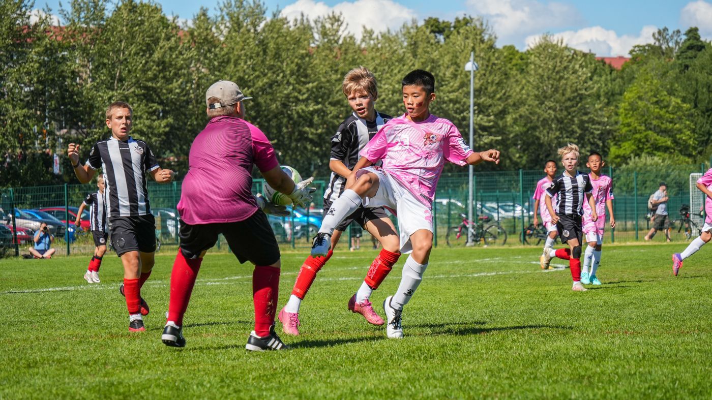 一群小男孩正在操場上踢足球。