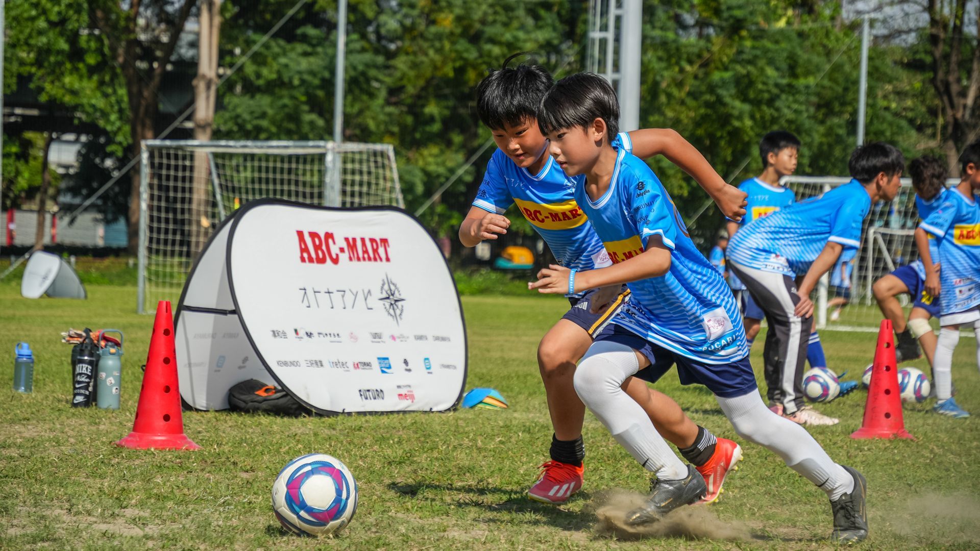 一群小男孩正在操場上踢足球。