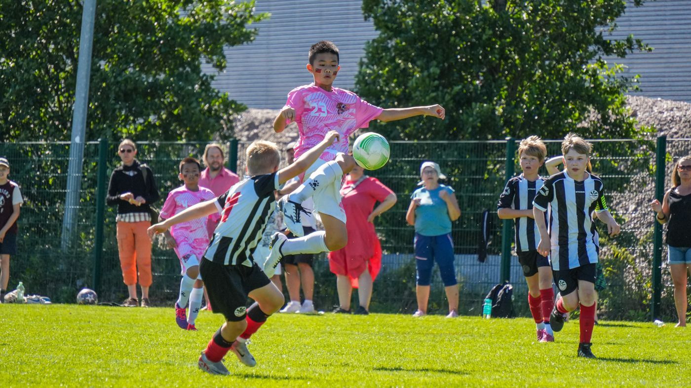 一群小男孩正在操場上踢足球。