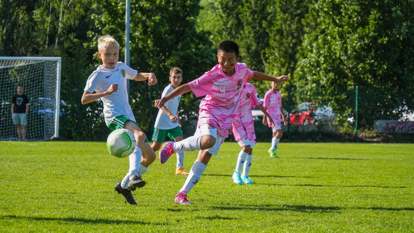 一群年輕女孩正在操場上踢足球。