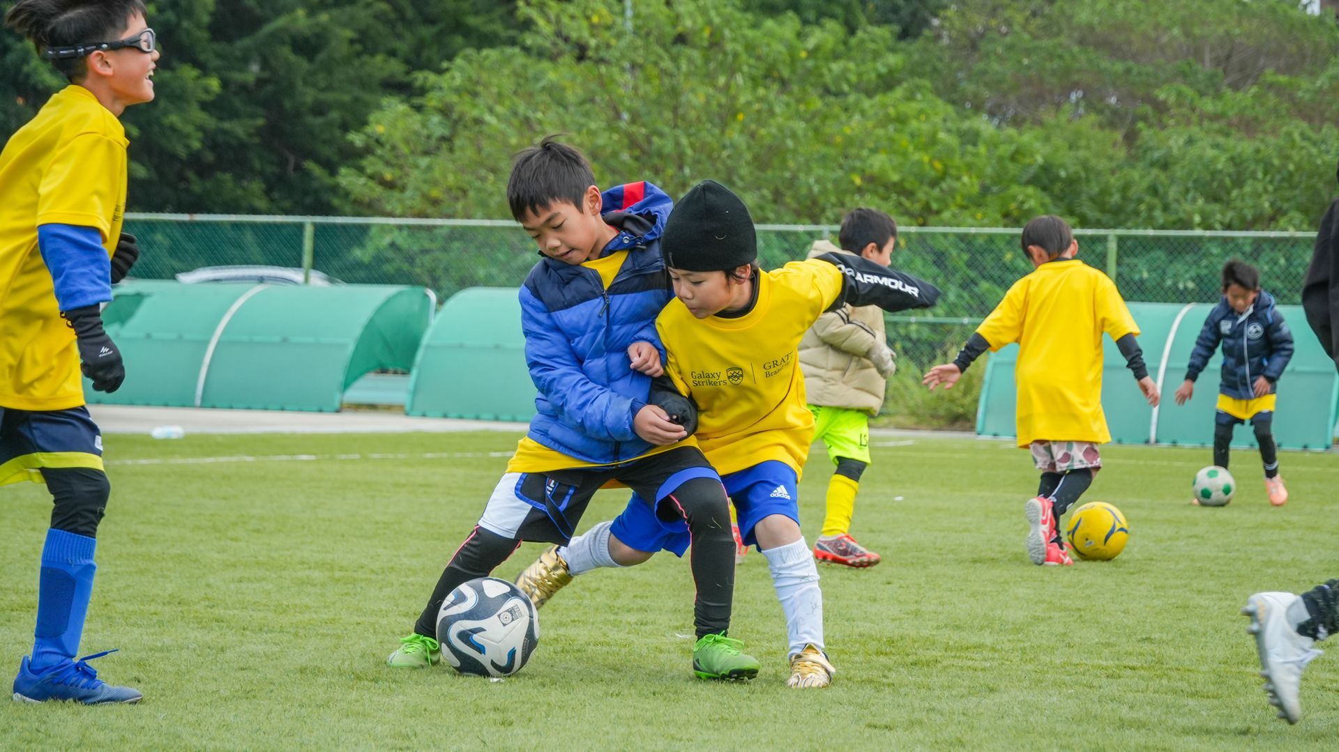 一群小男孩正在操場上踢足球。