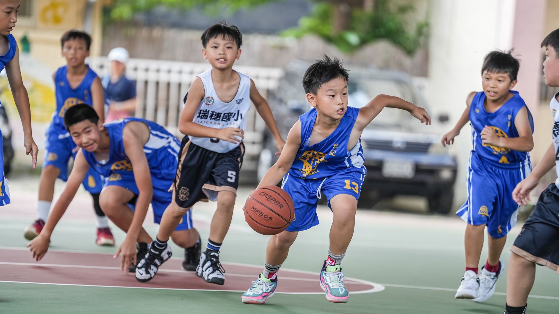 一群小男孩正在球場上打籃球。