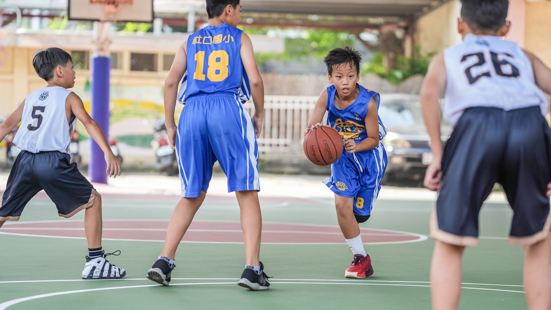一群小男孩正在球場上打籃球。