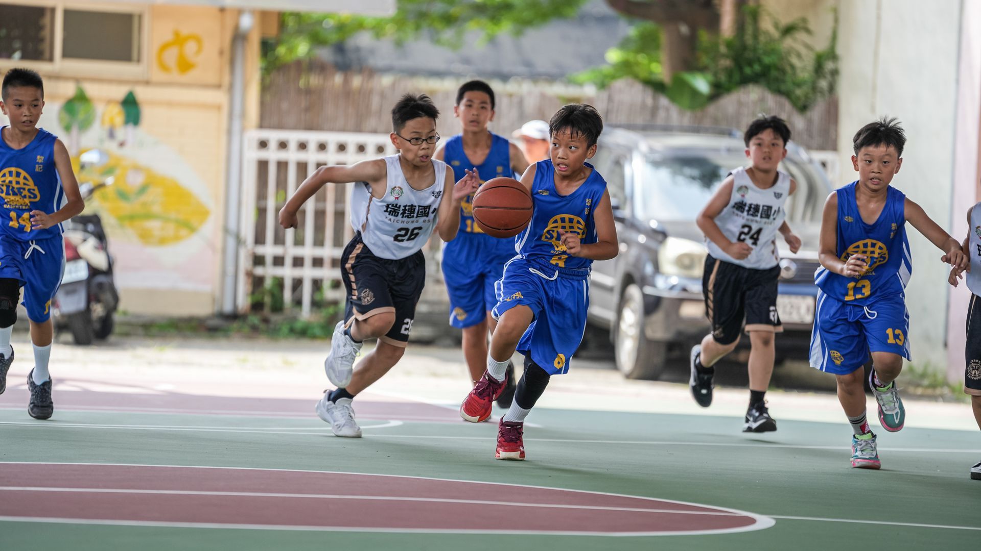 一群小男孩正在球場上打籃球。