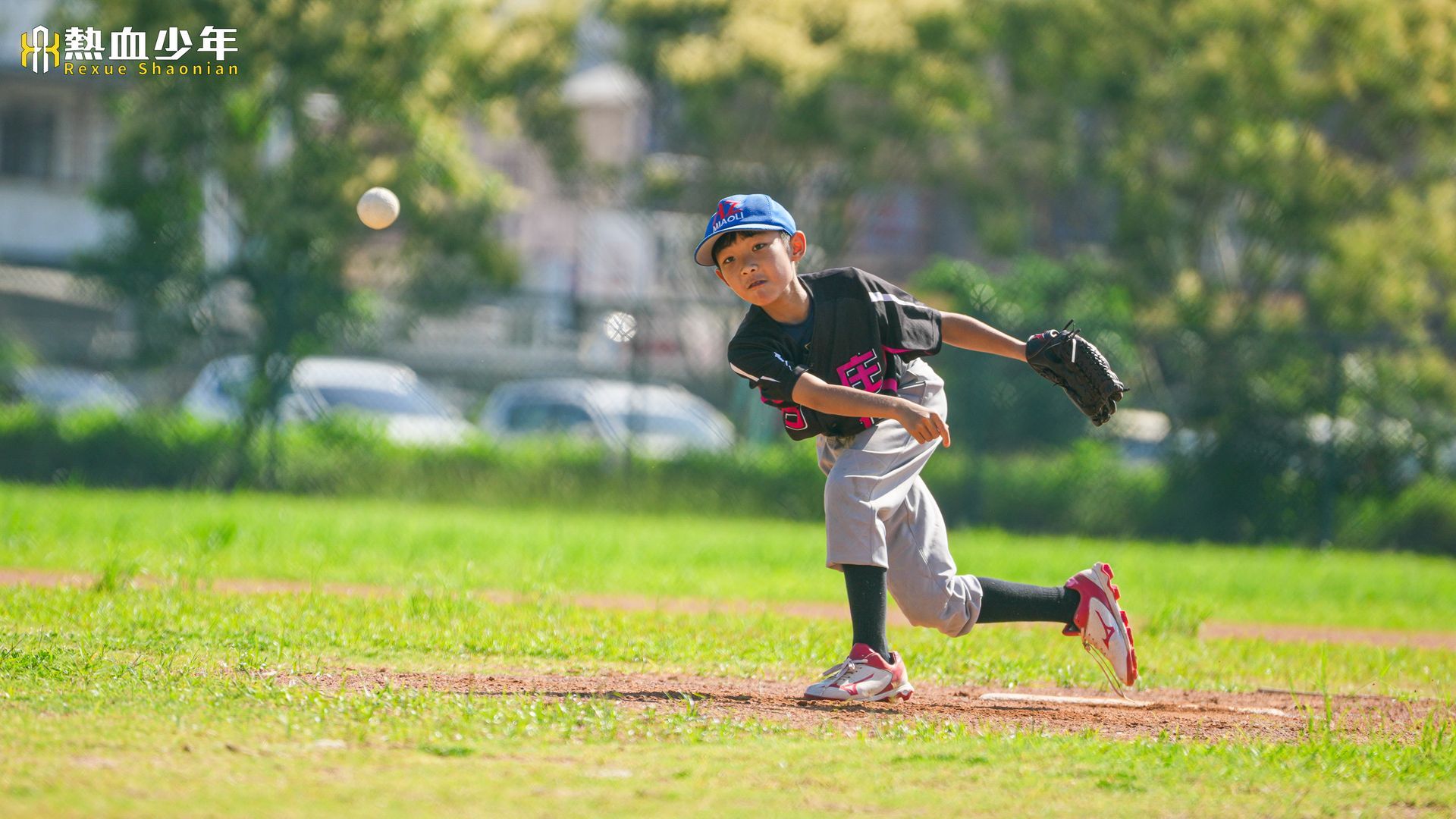 一群小男孩正在操場上踢足球。