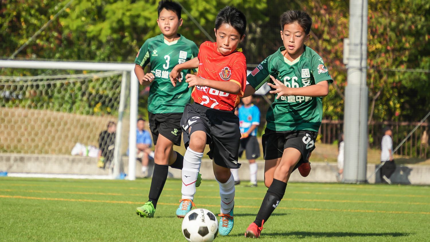 一群小男孩正在操場上踢足球。