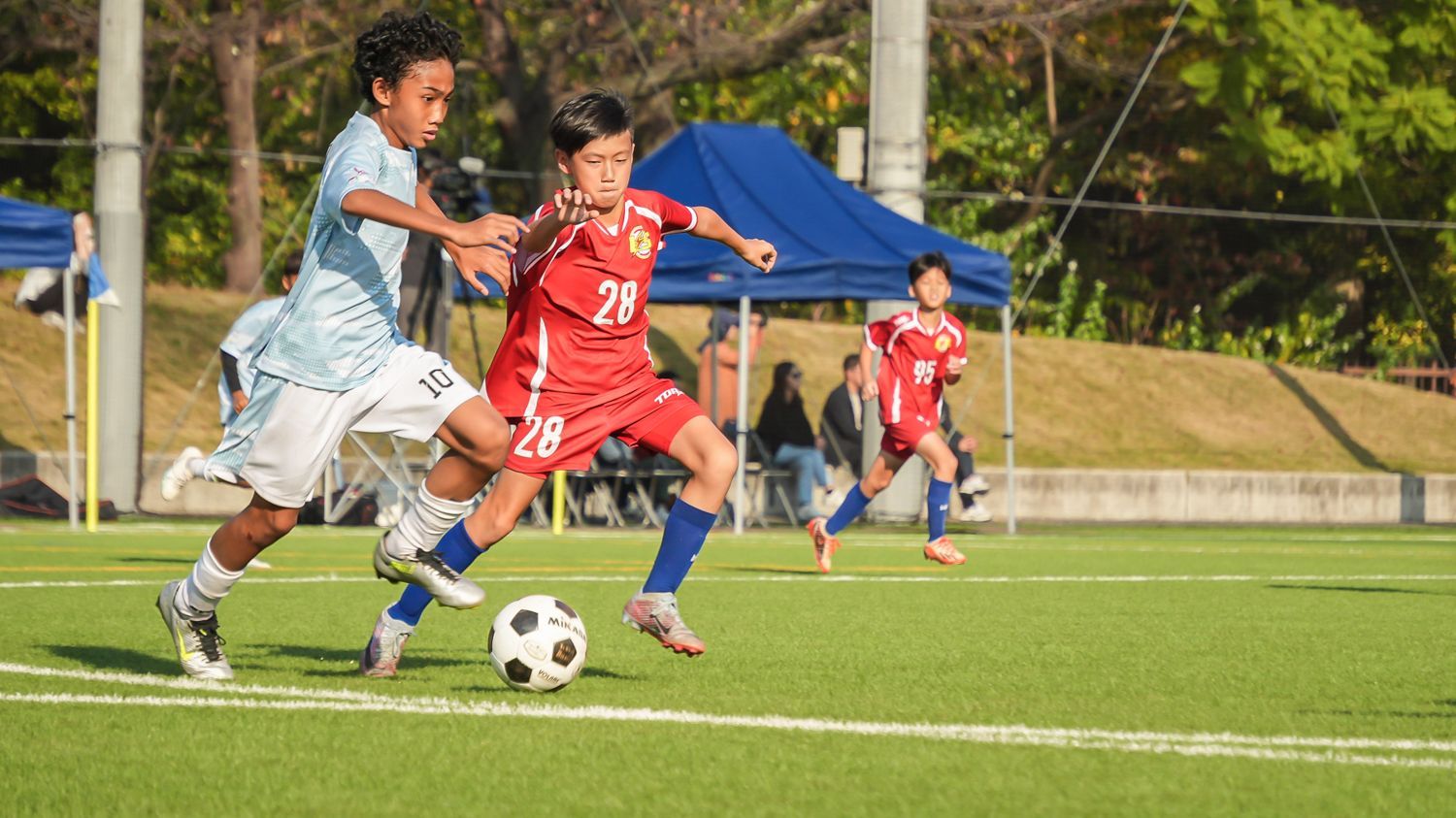 一群小男孩正在操場上踢足球。
