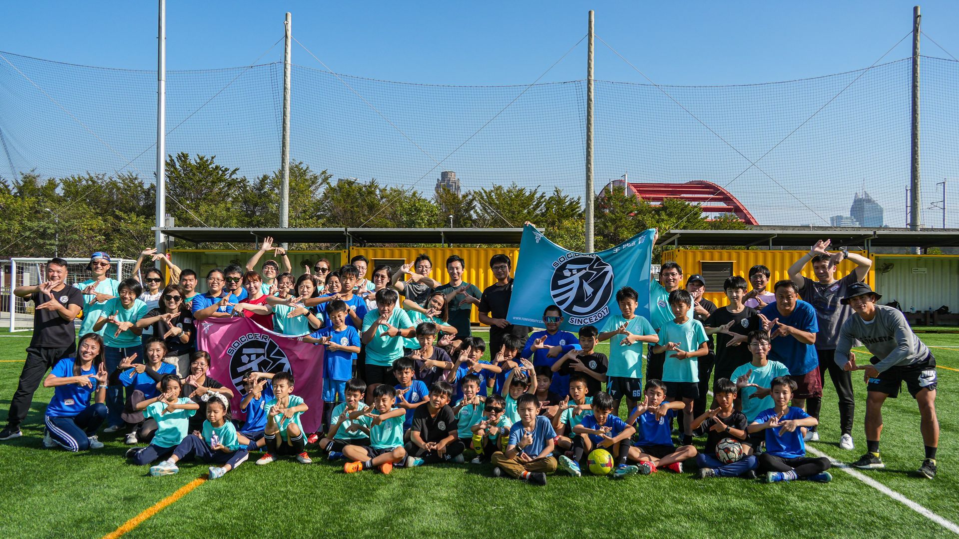 一群人在足球場上擺姿勢拍照。