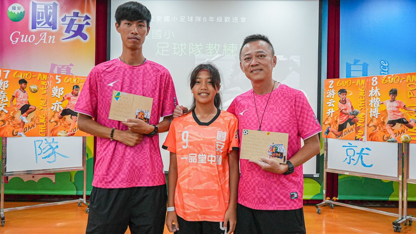 一群人並排站在投影機螢幕前。