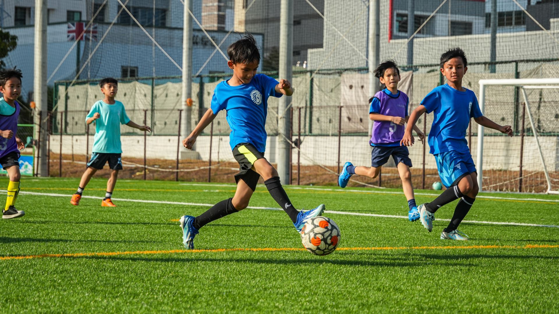 一群小男孩正在操場上踢足球。