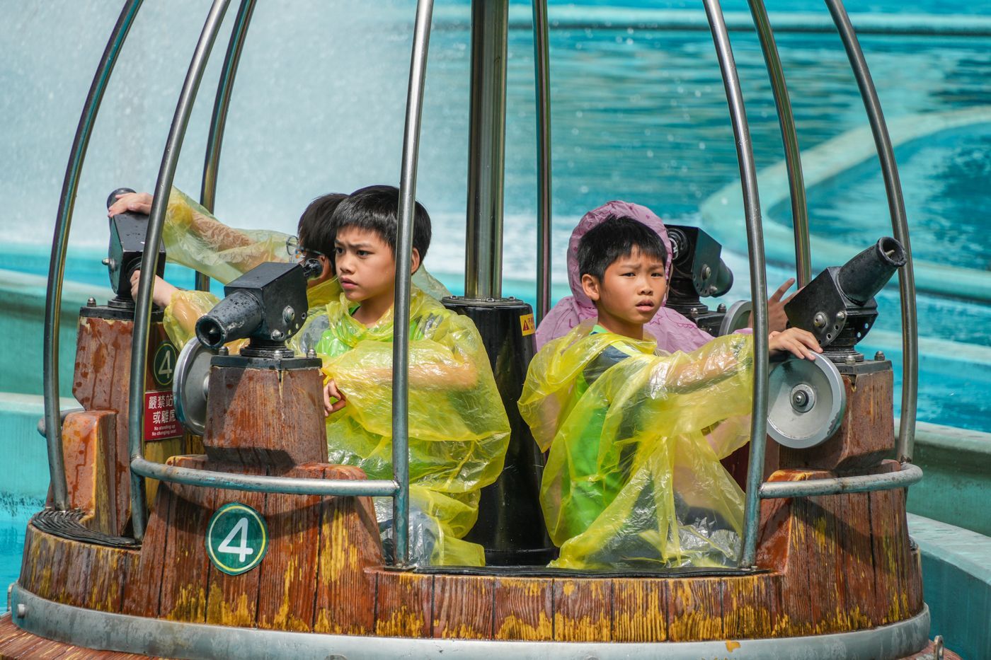 一群穿著黃色雨衣的孩子正在騎車。