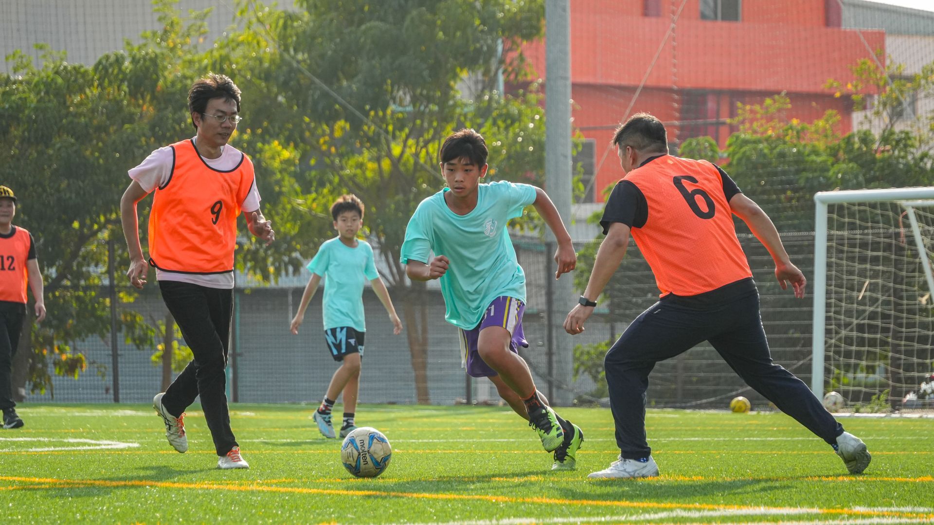 一群人正在操場上踢足球。