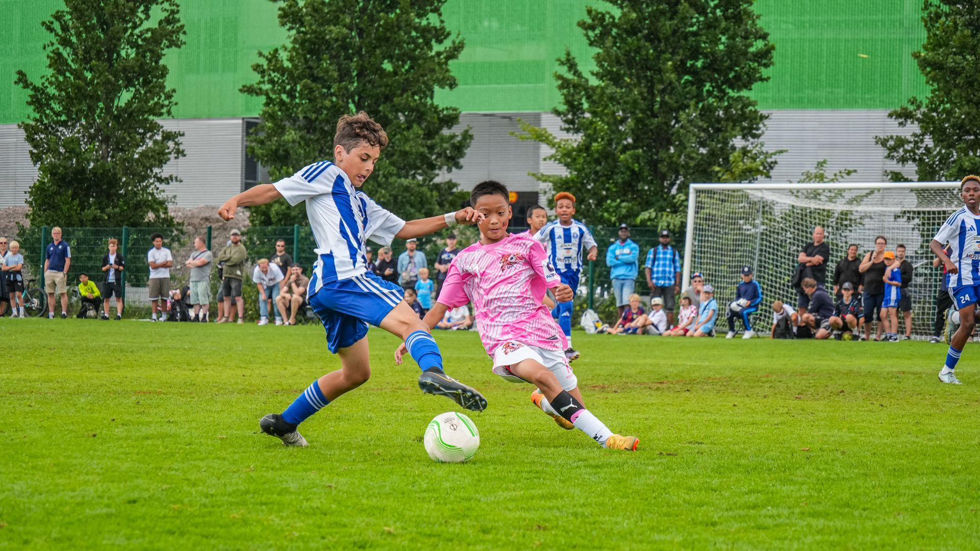 一群小男孩正在操場上踢足球。