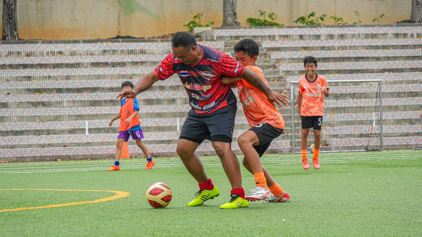 一個男人和一個男孩正在球場上踢足球。