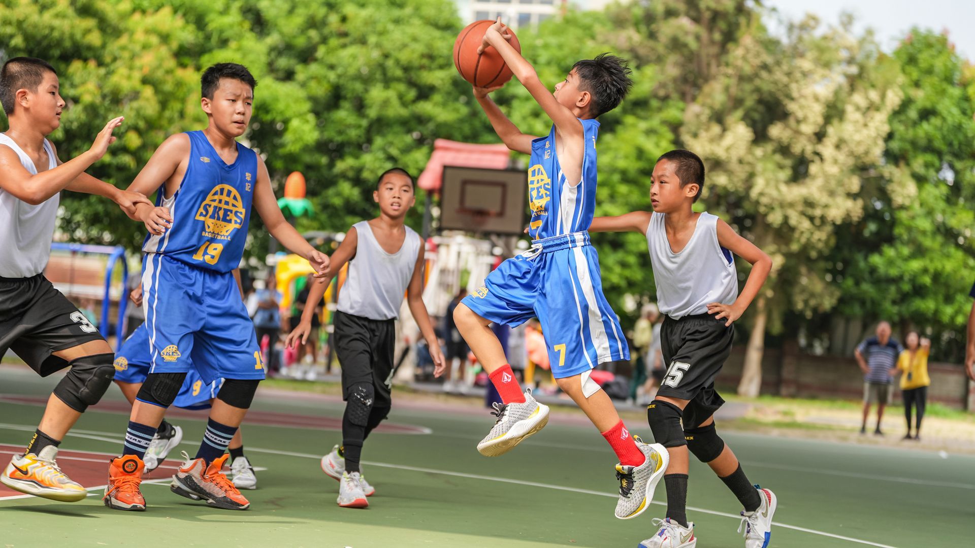 一群小男孩正在球場上打籃球。