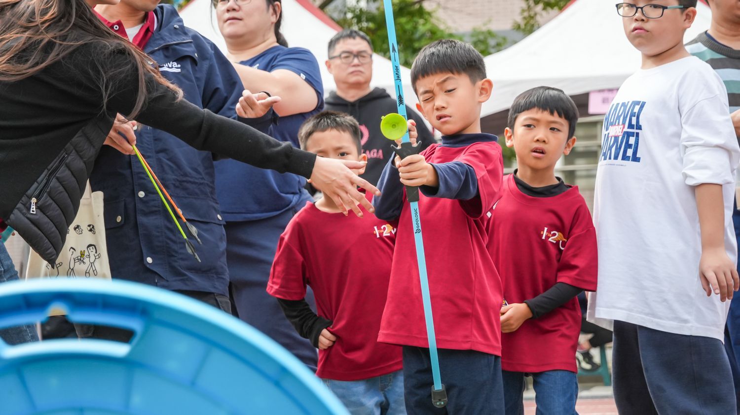 一群孩子拿著一根棍子站成一排。