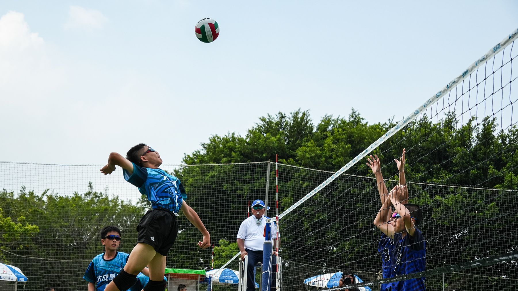 一群人正在操場上打排球。