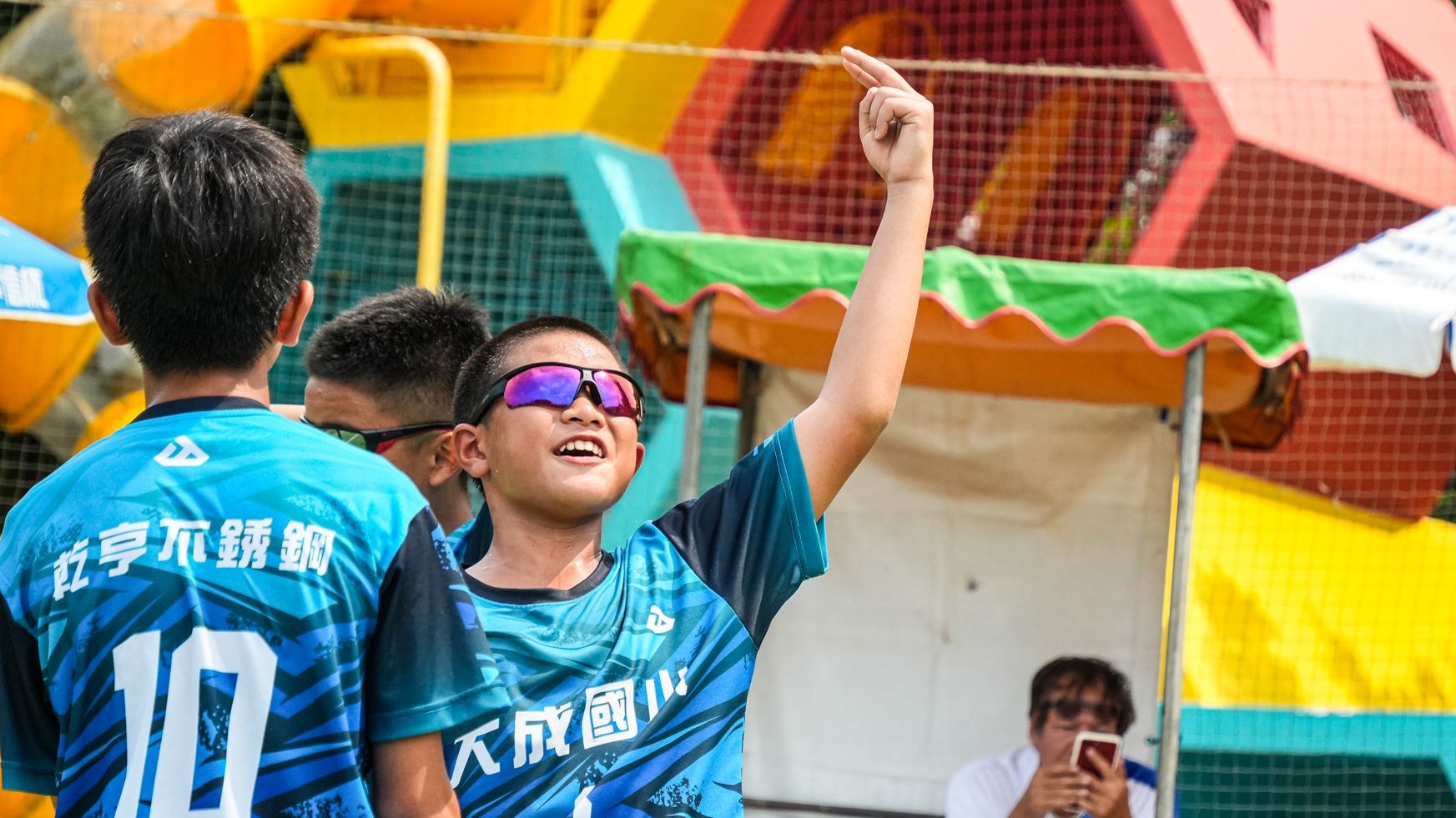 一個戴著墨鏡、穿著印有數字 10 的藍色襯衫的小男孩。