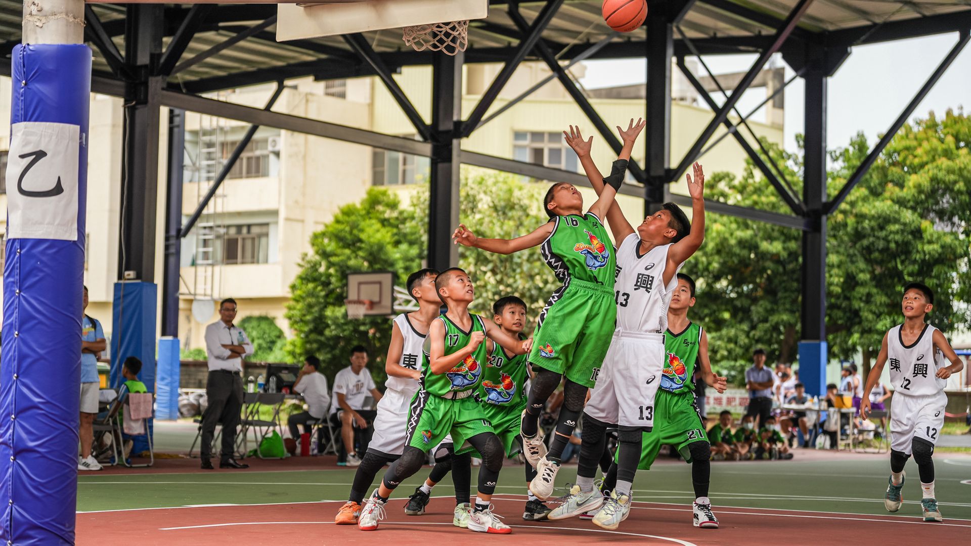 一群小男孩正在球場上打籃球。