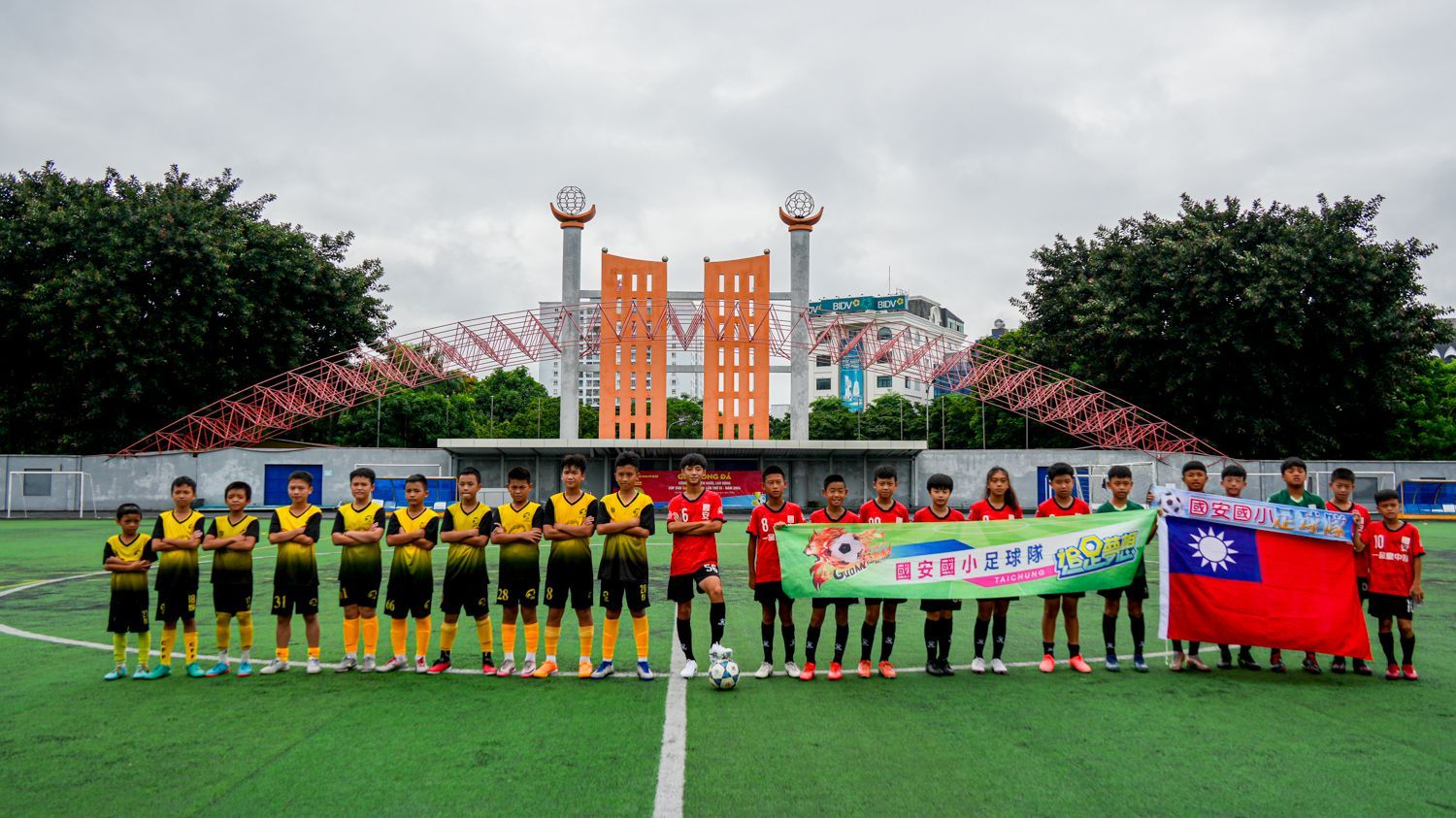 一群人舉著旗幟站在足球場上