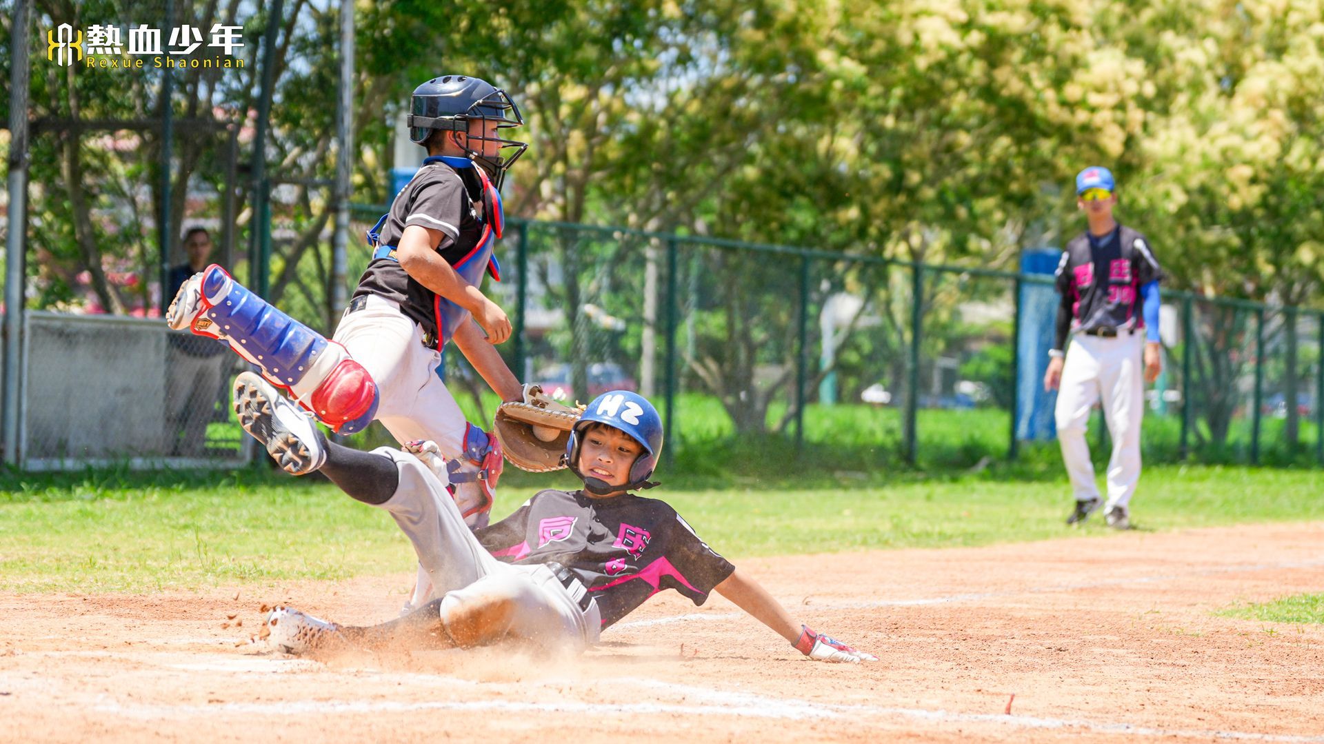 一個小男孩在記分板前拿著棒球棒。
