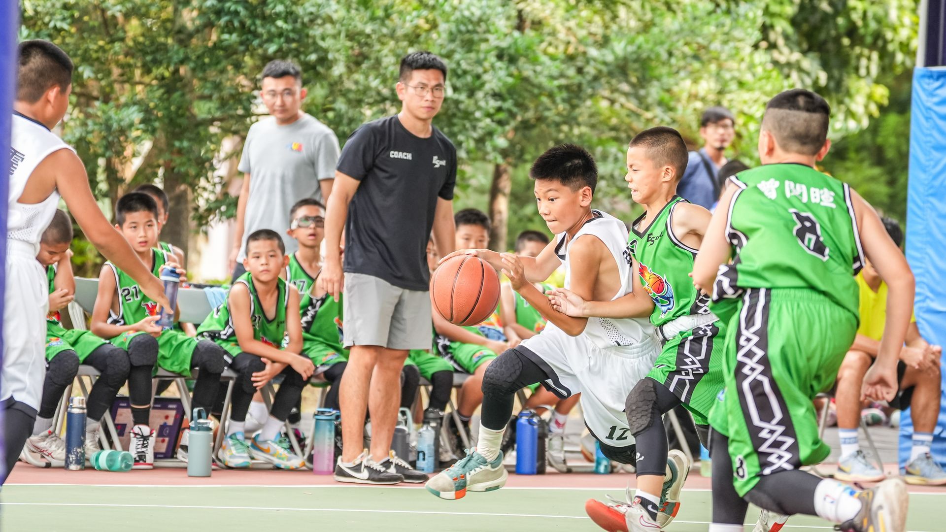 一群小男孩正在球場上打籃球。