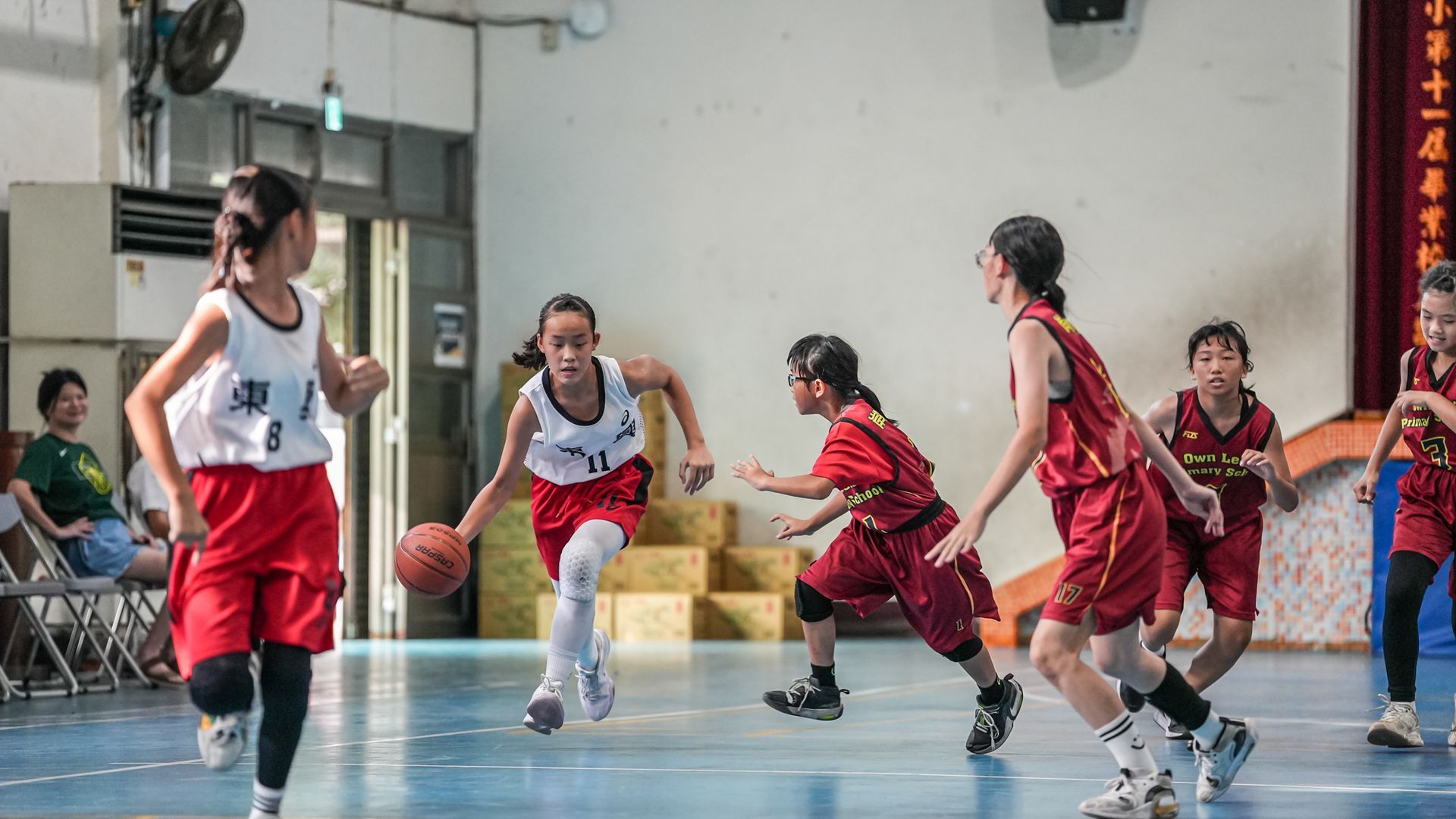 一群年輕女孩正在球場上打籃球。