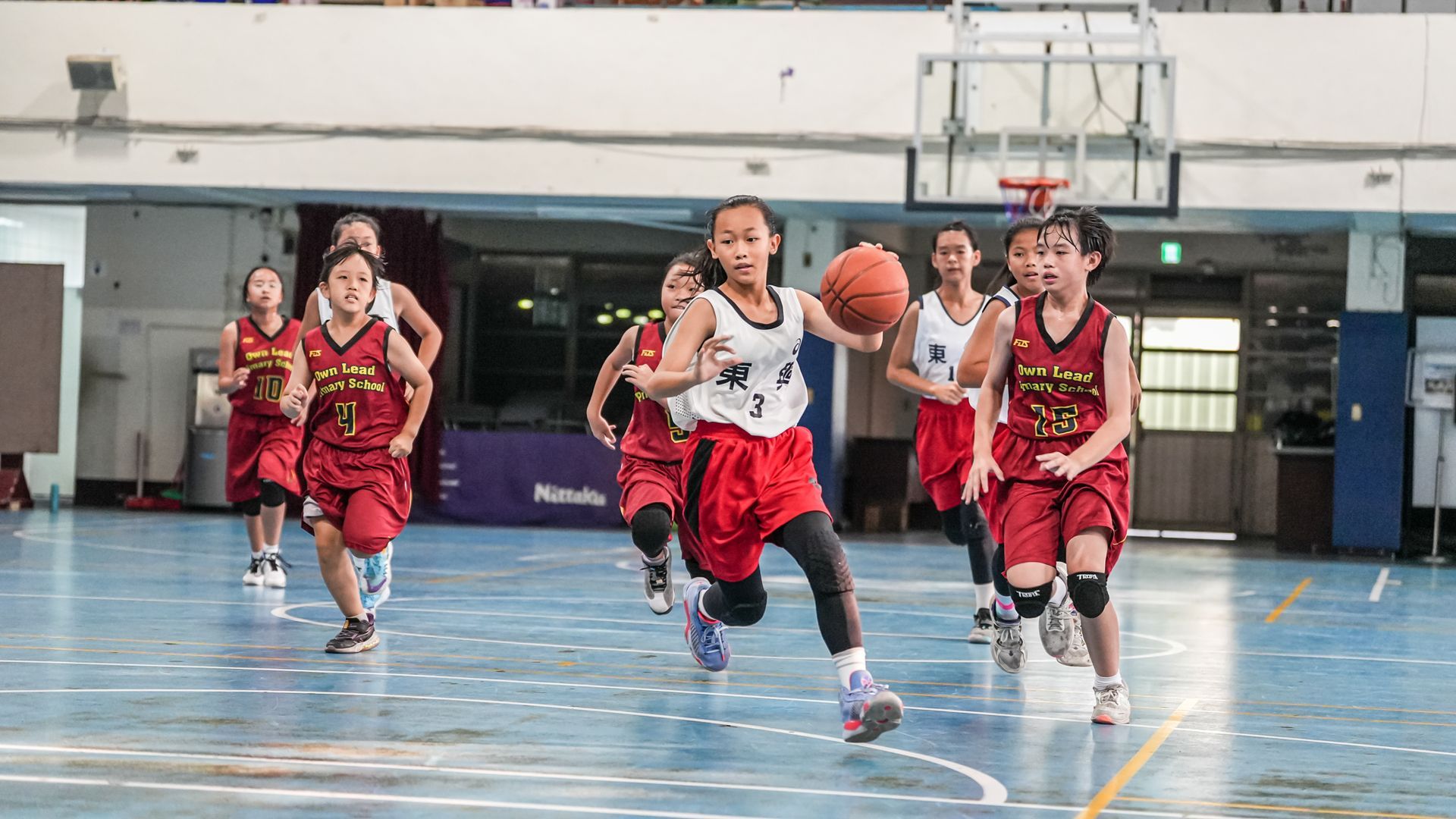 一群年輕女孩正在球場上打籃球。