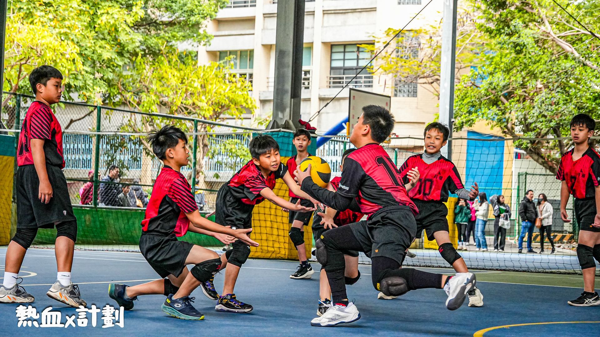 一群小男孩正在球場上打排球。