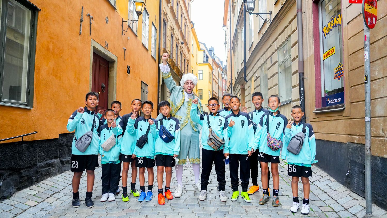 一群孩子並排站在鵝卵石街道上。