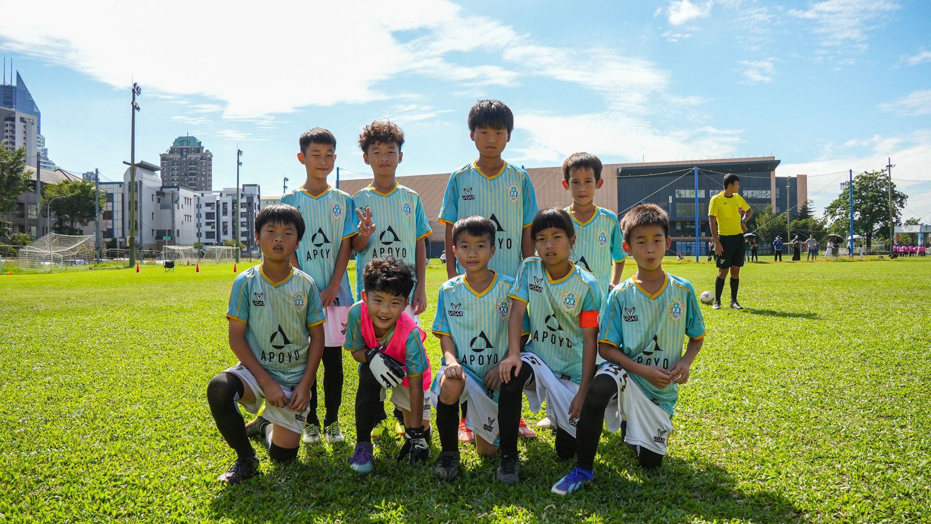 一群小男孩正在足球場上擺姿勢拍照。