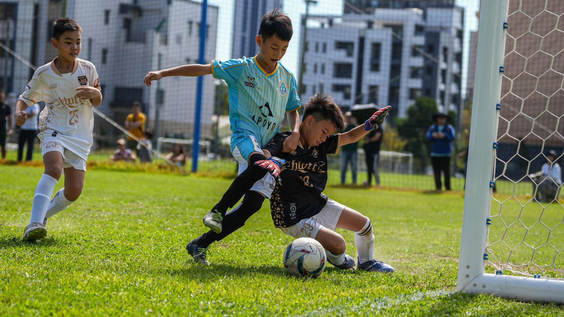 一群小男孩正在操場上踢足球。