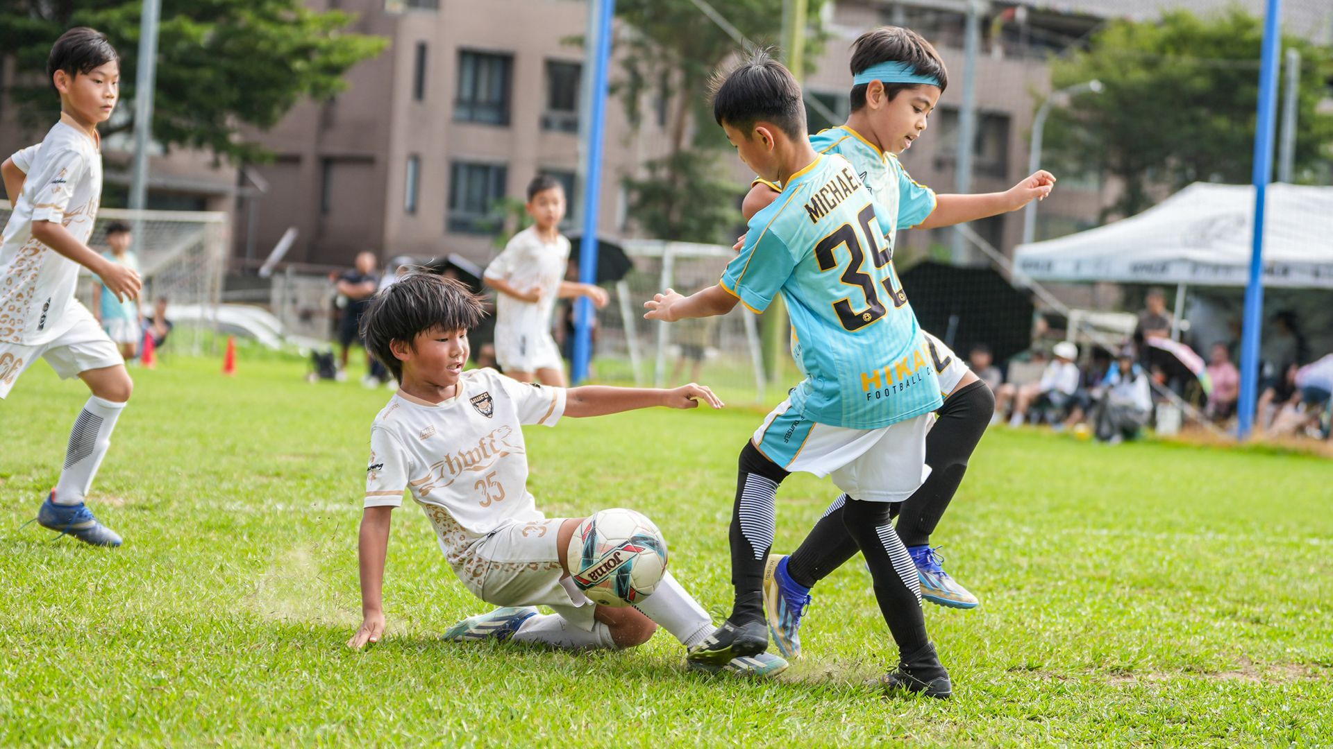 一群小男孩正在操場上踢足球。