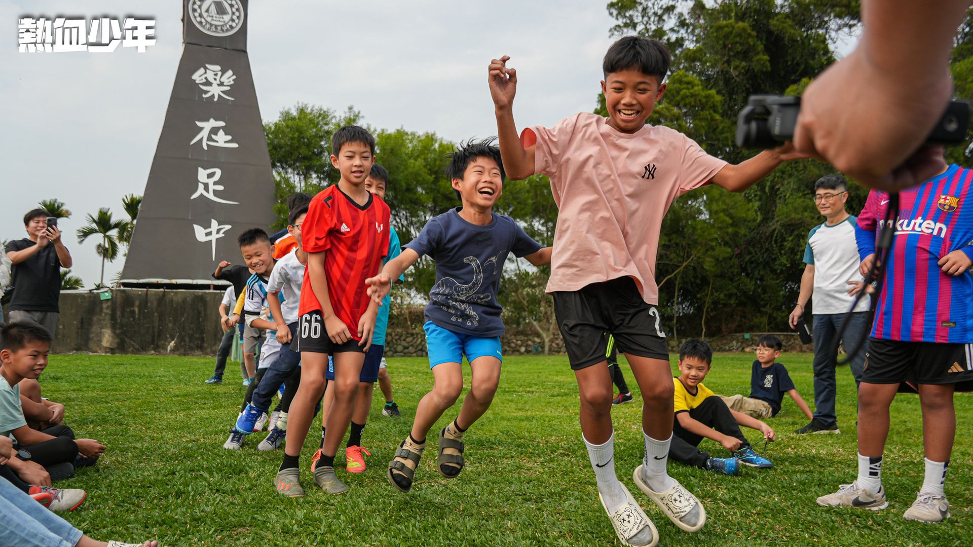 一群小男孩在足球場上手牽手。