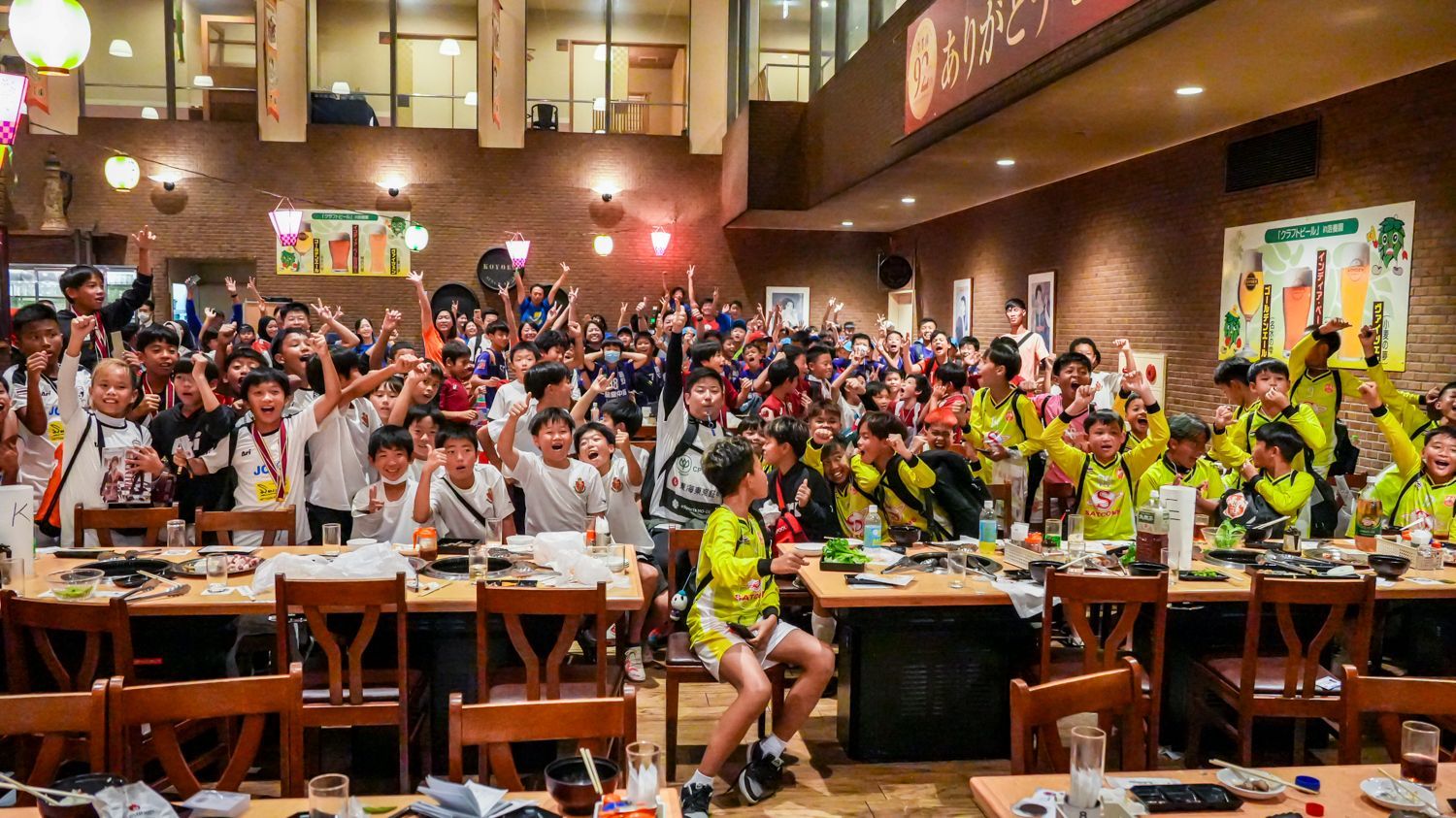 一家餐廳裡，一大群人坐在桌子旁。