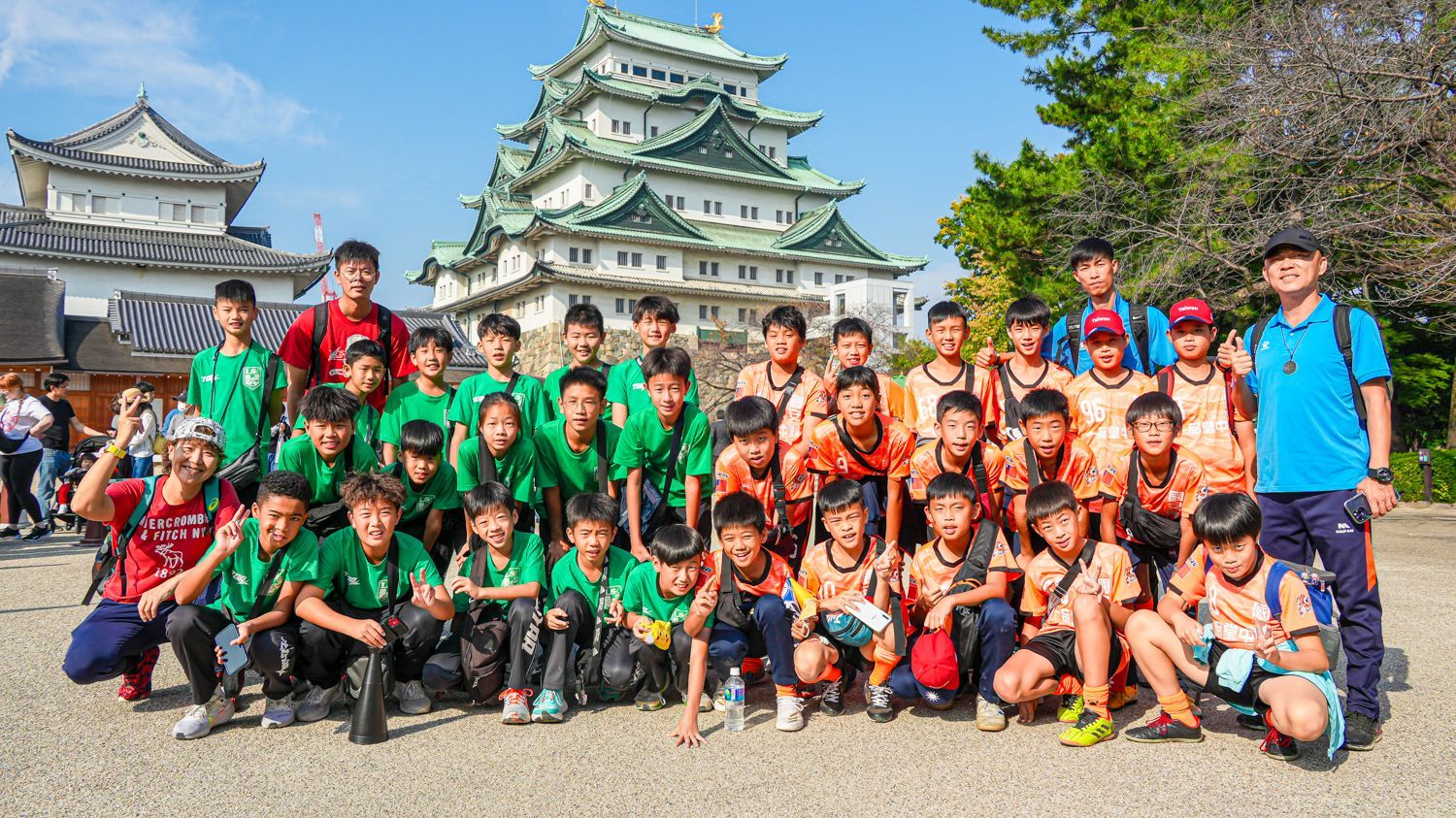 一群孩子在城堡前擺姿勢拍照。