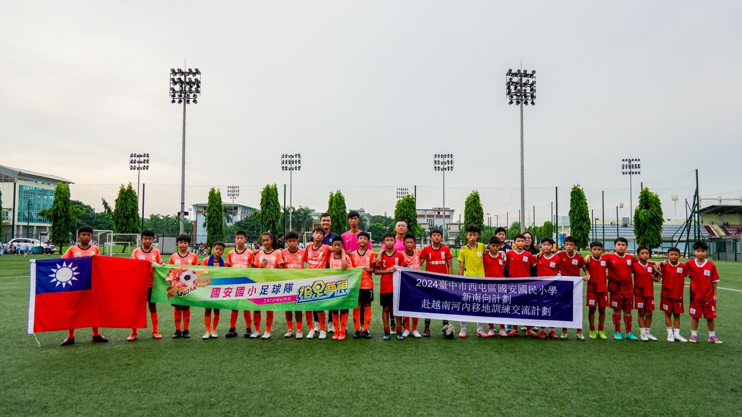 一群人舉著旗幟站在足球場上。