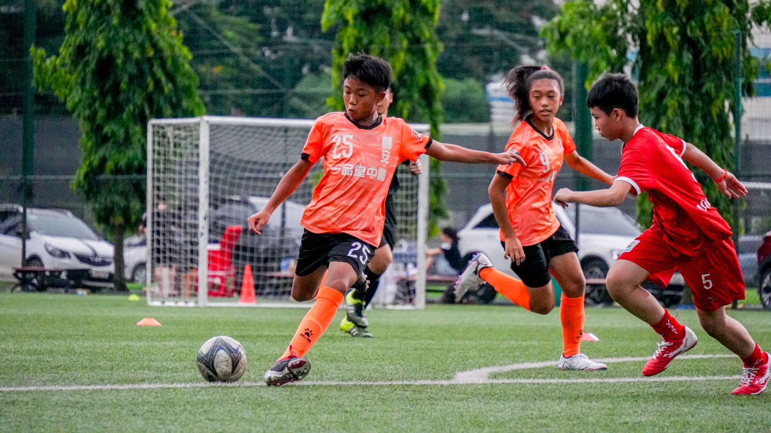 一群小男孩正在操場上踢足球。