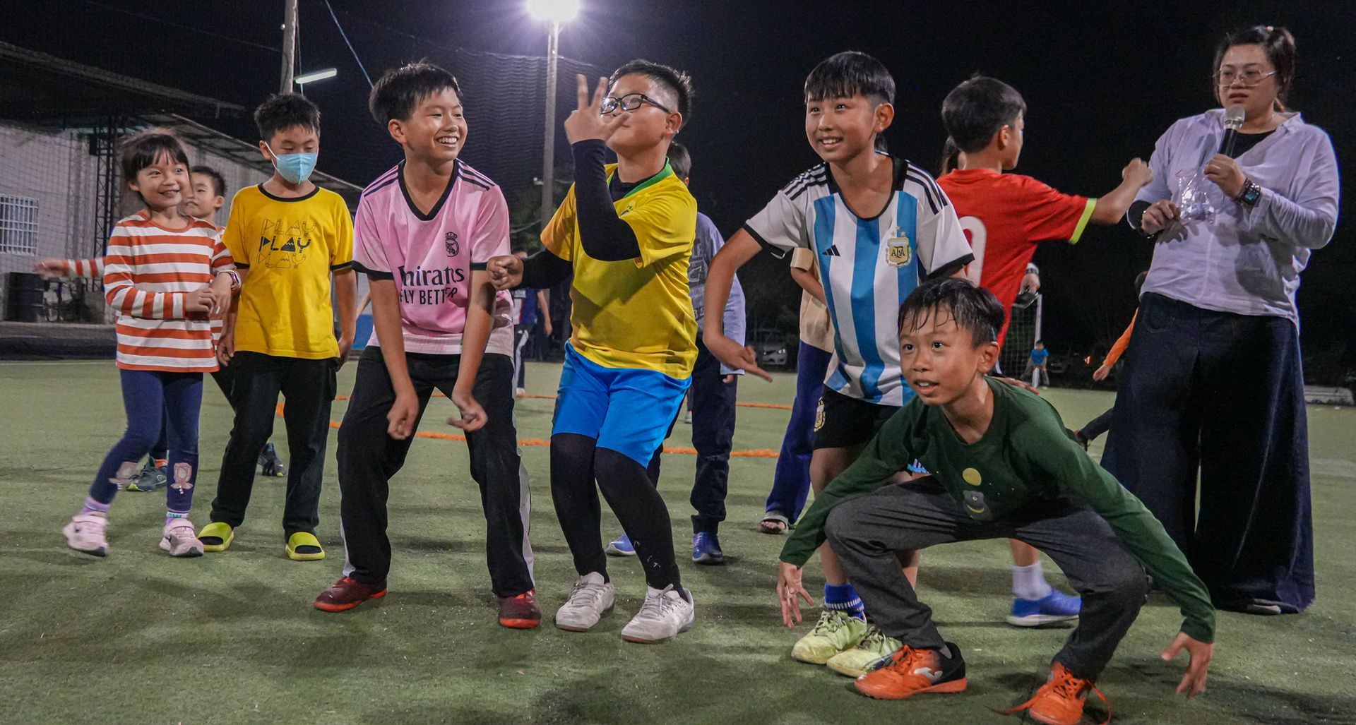 一群孩子在足球場上並排站立。