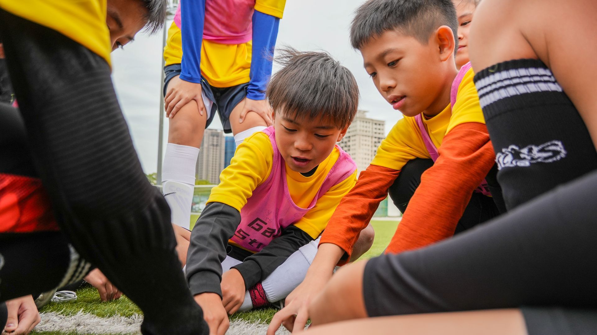 一群小男孩坐在足球場上。