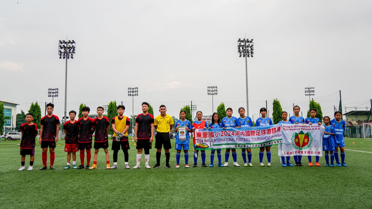 一群足球員正在球場上擺姿勢拍照。