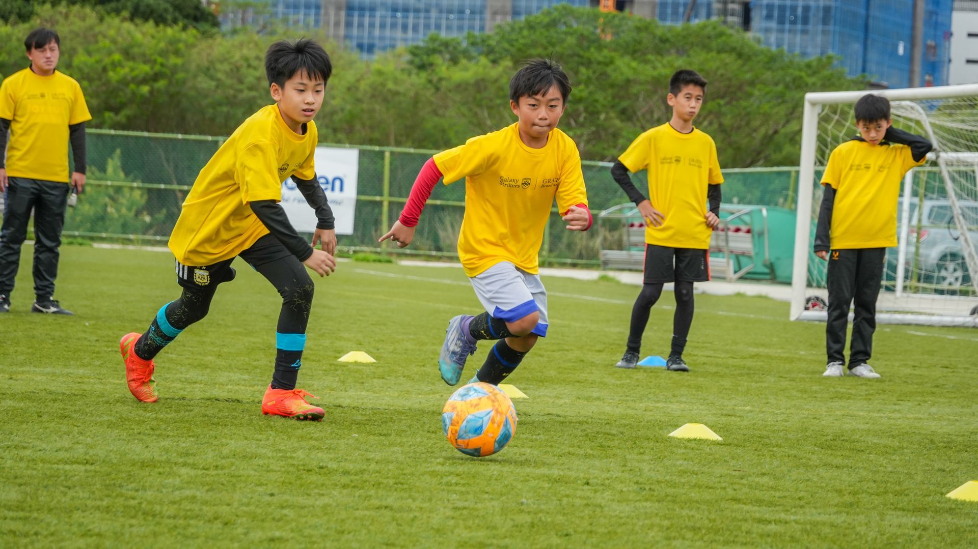 一群小男孩正在操場上踢足球。