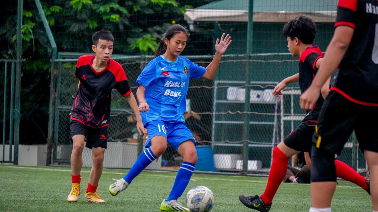 一群年輕人正在操場上踢足球。